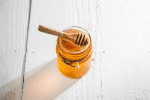 Jar of honey sitting on a table