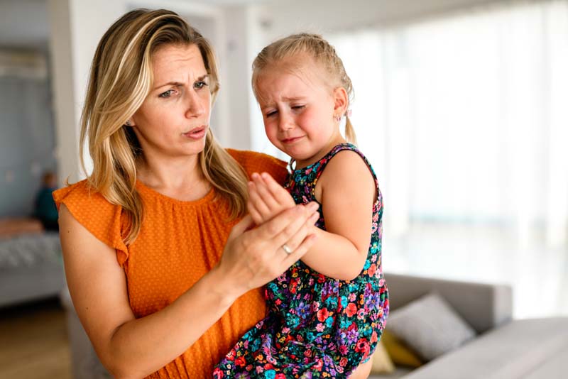 Mother comforting her crying child who had allergic reaction to bee sting, can allergies go away?