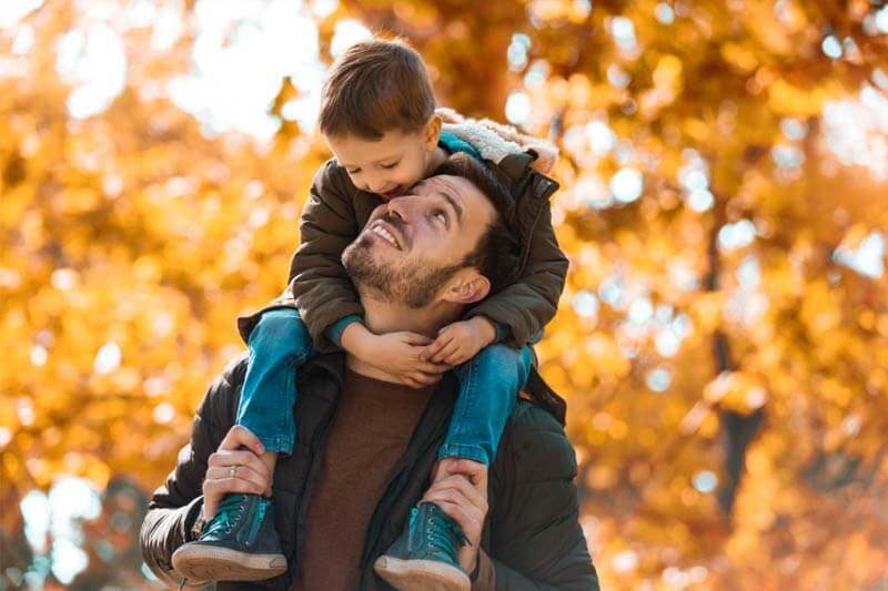 Child on shoulders of father